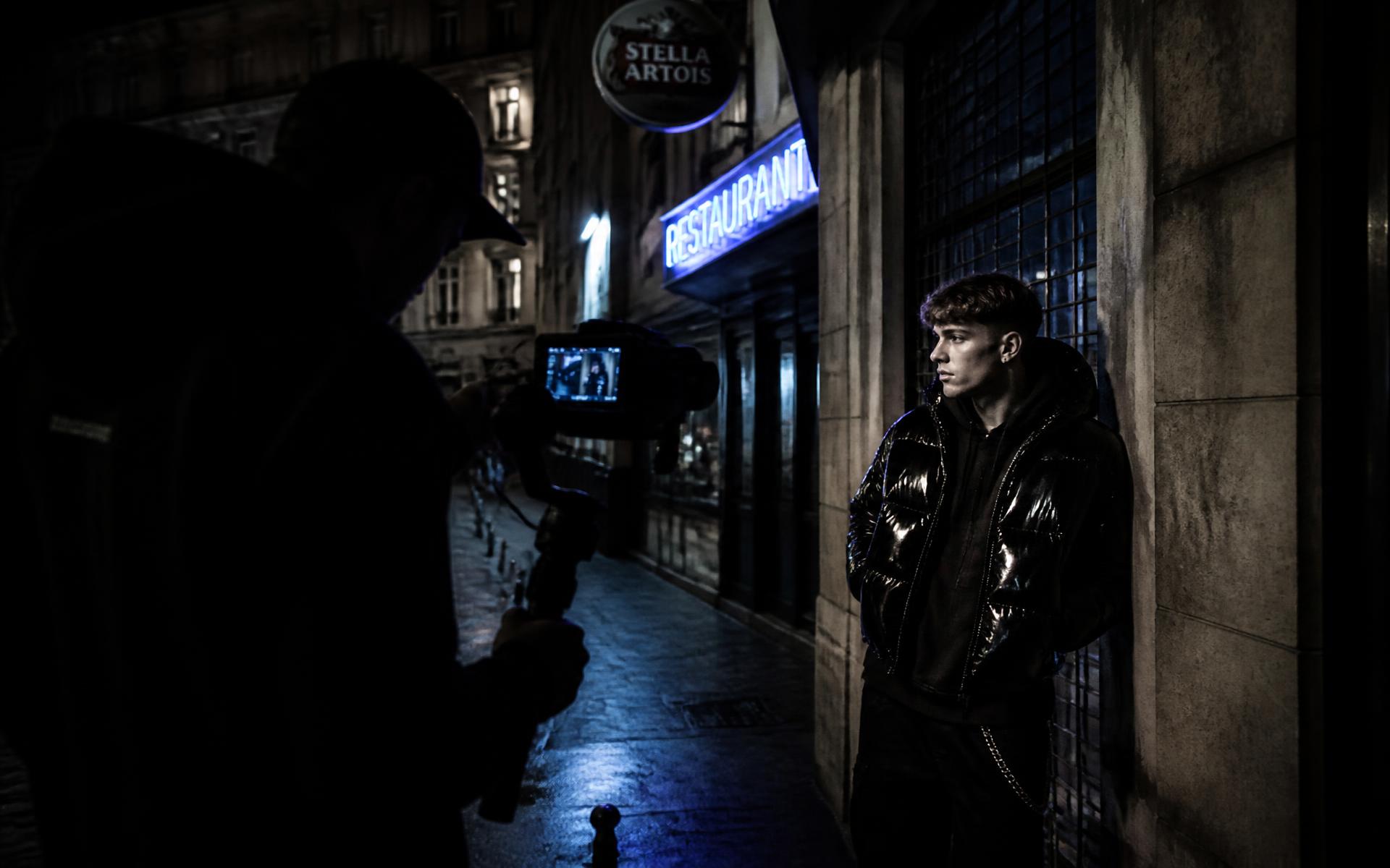Tournage nocturne d'un créateur devant un restaurant en Belgique